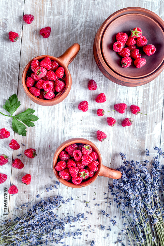 laveder composition with raspberry in pottery cup rustic background top view