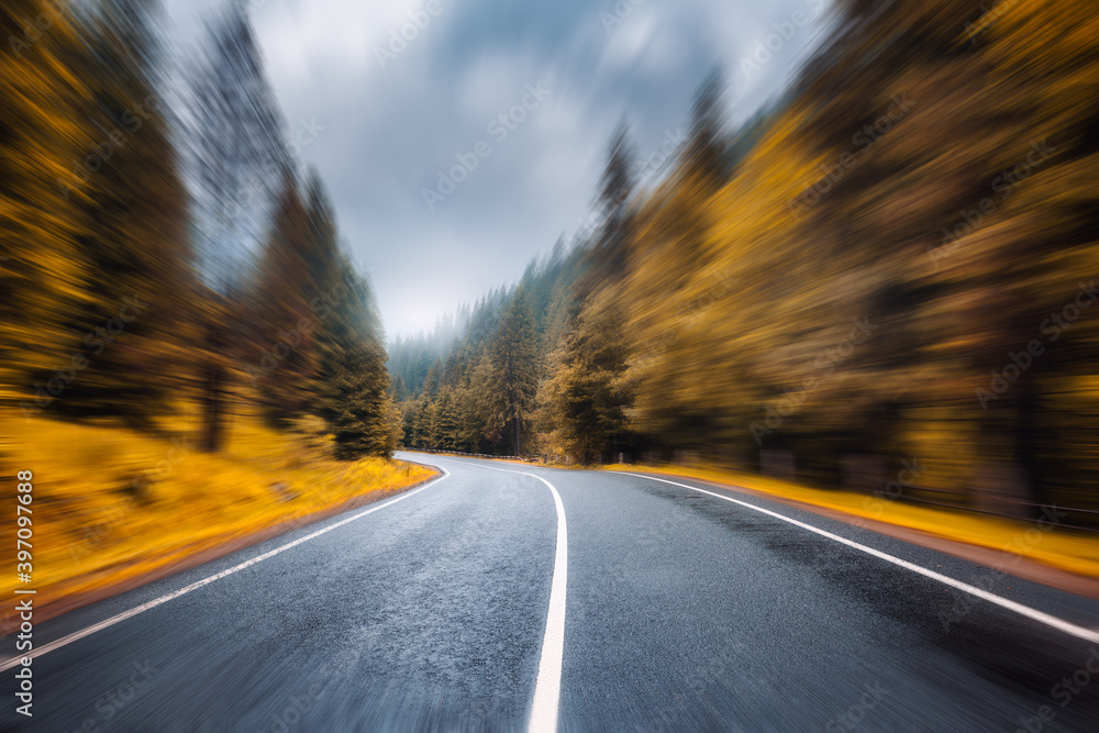 雨天秋雾林中的道路，具有运动模糊效果。美丽的山路和模糊