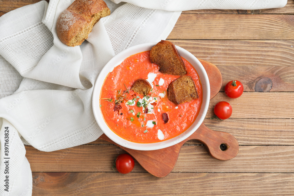 Bowl of tomato cream soup on wooden   background