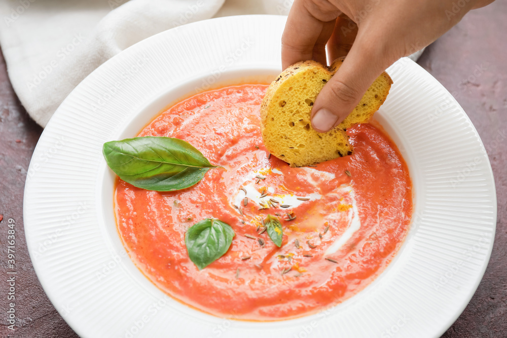 Woman eating tomato cream soup