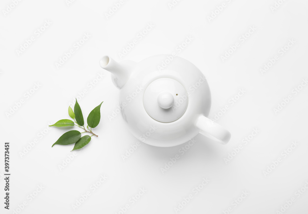 白底茶壶和绿茶叶