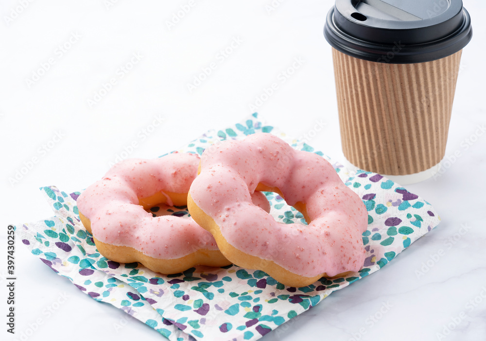 Hot coffee with pink donuts on a marble background