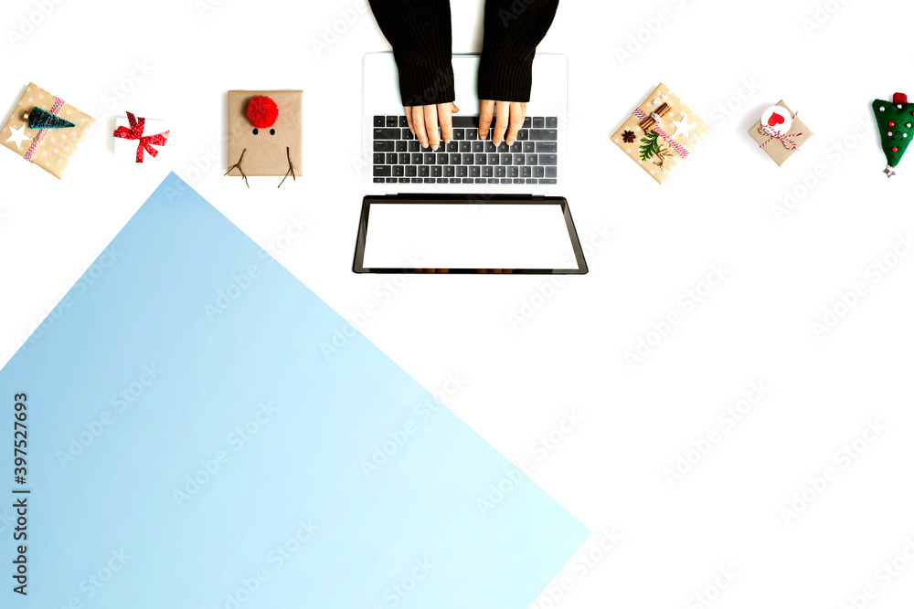 Person using a laptop computer with Christmas gift boxes from above