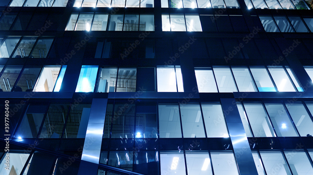 Pattern of office buildings windows illuminated at night. Lighting with Glass architecture facade de