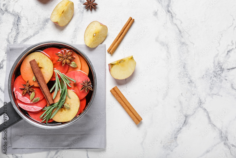 Saucepan with hot mulled wine on white background