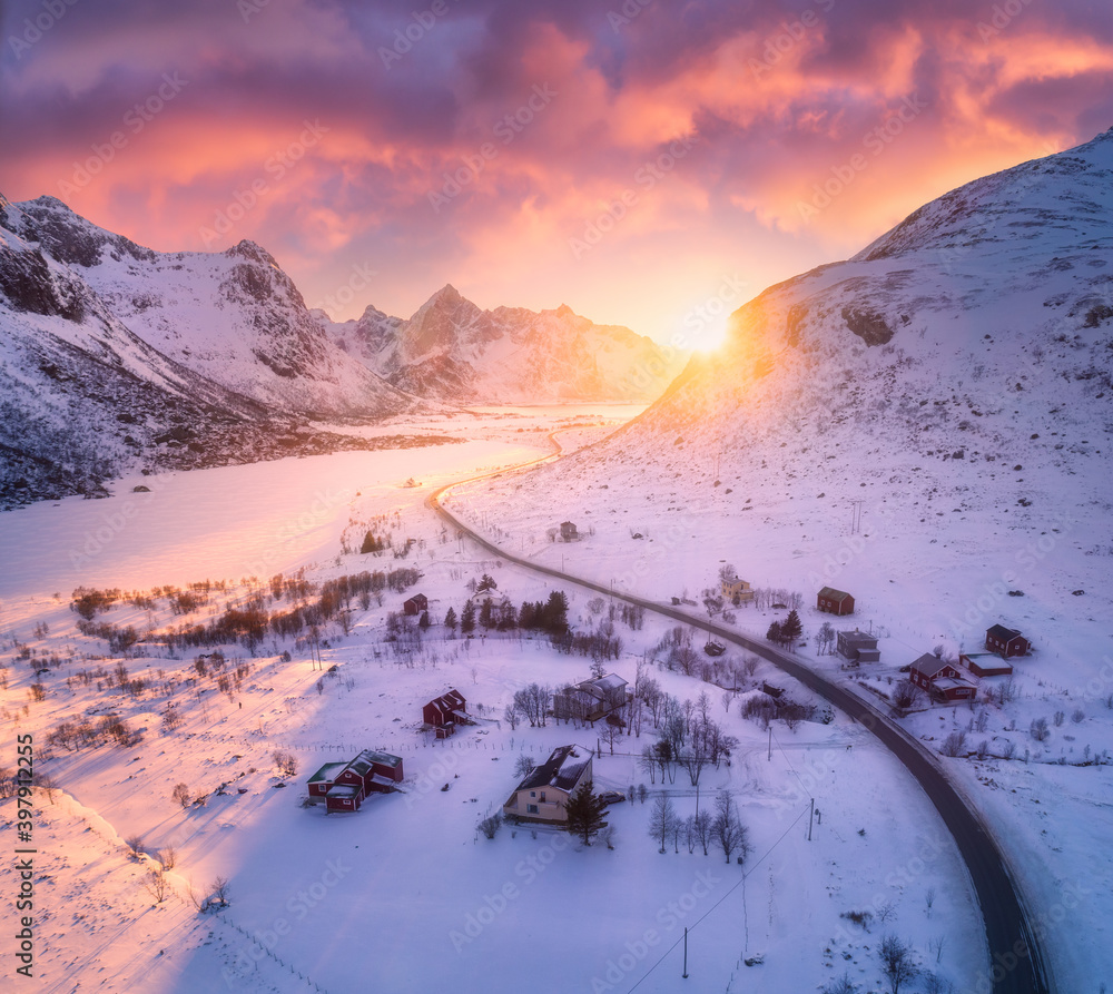 日落时分，冬季雪山中的美丽道路。鸟瞰图。挪威罗弗敦群岛。科罗拉多州