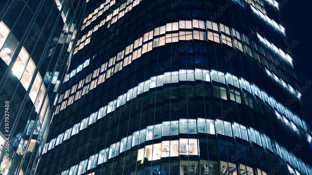 Pattern of office buildings windows illuminated at night. Lighting with Glass architecture facade de