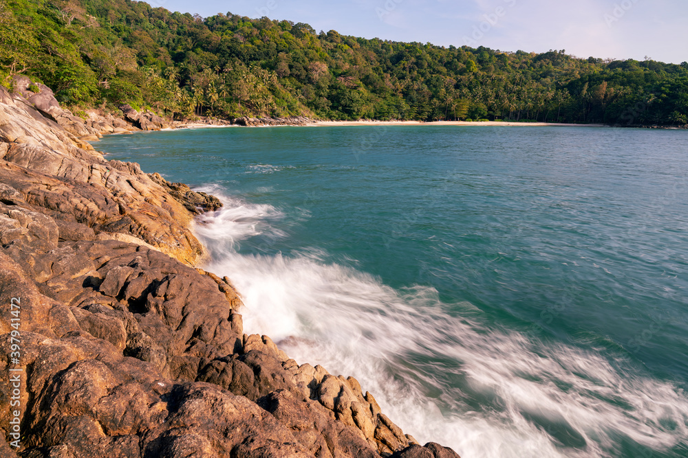 海浪冲击岩石海岸，海浪在普吉岛Tha海滩飞溅成白色泡沫