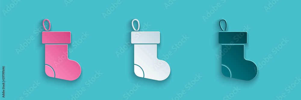 Paper cut Christmas stocking icon isolated on blue background. Merry Christmas and Happy New Year. P