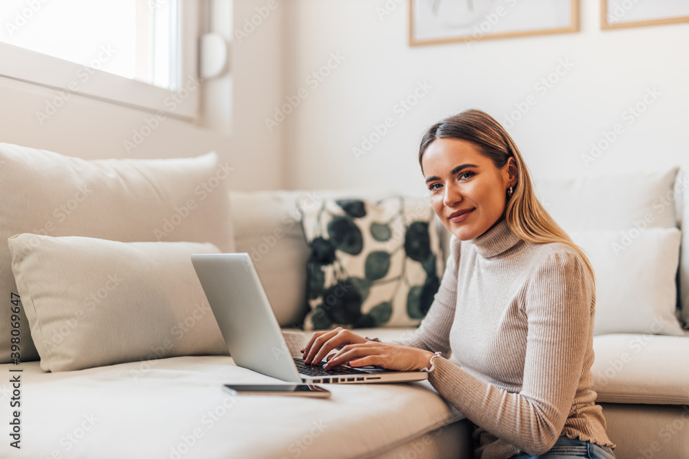 Smiling face, typing something while looking at camera.