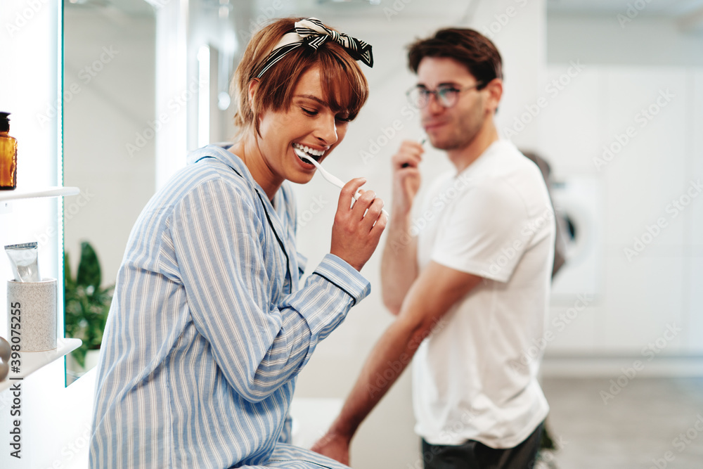 Couple brushing their teeth and laughing