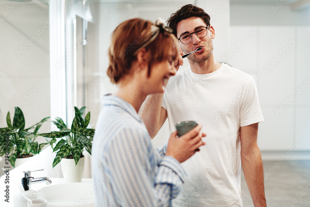 Man brushing his teeth with his girlfriend