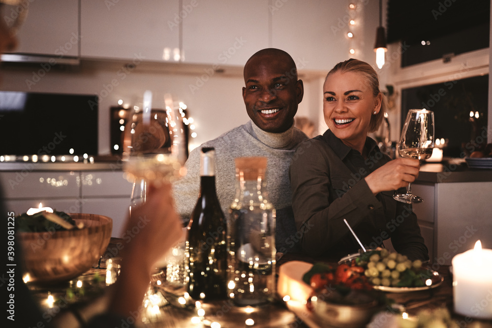 Smiling couple talking with friends at a dinner party