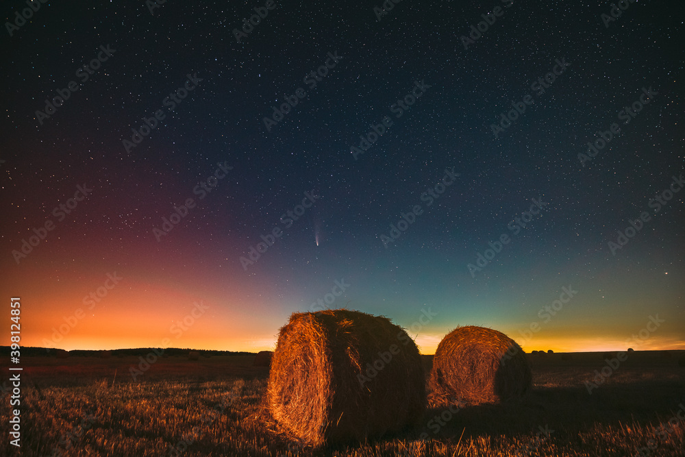 Neowise C2020 F3彗星在夏季农田干草堆上方的夜空中。夜空中的星星