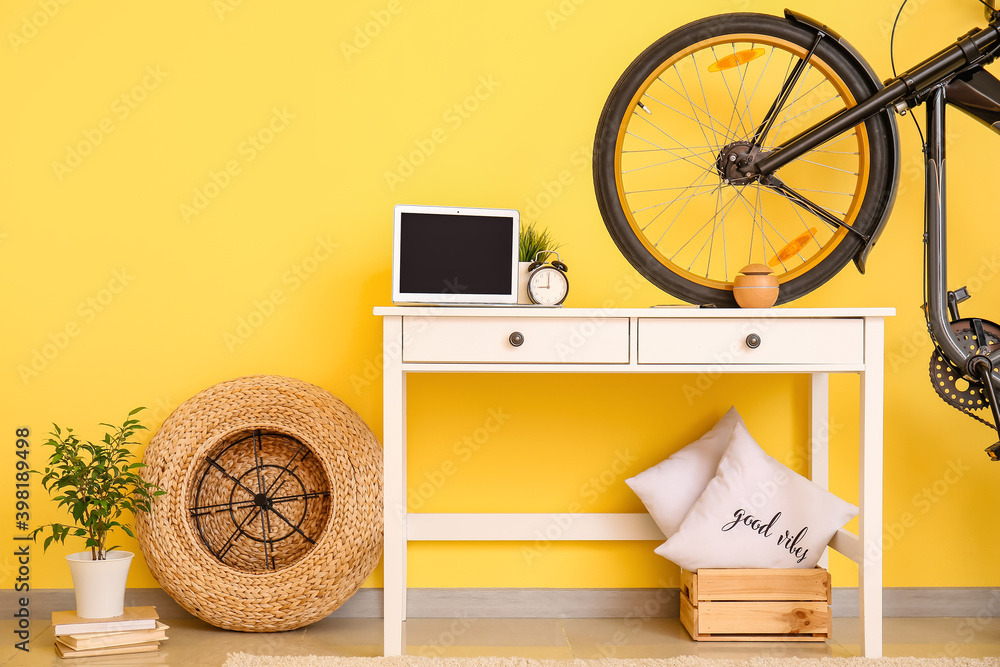 Interior of modern room with bicycle and laptop