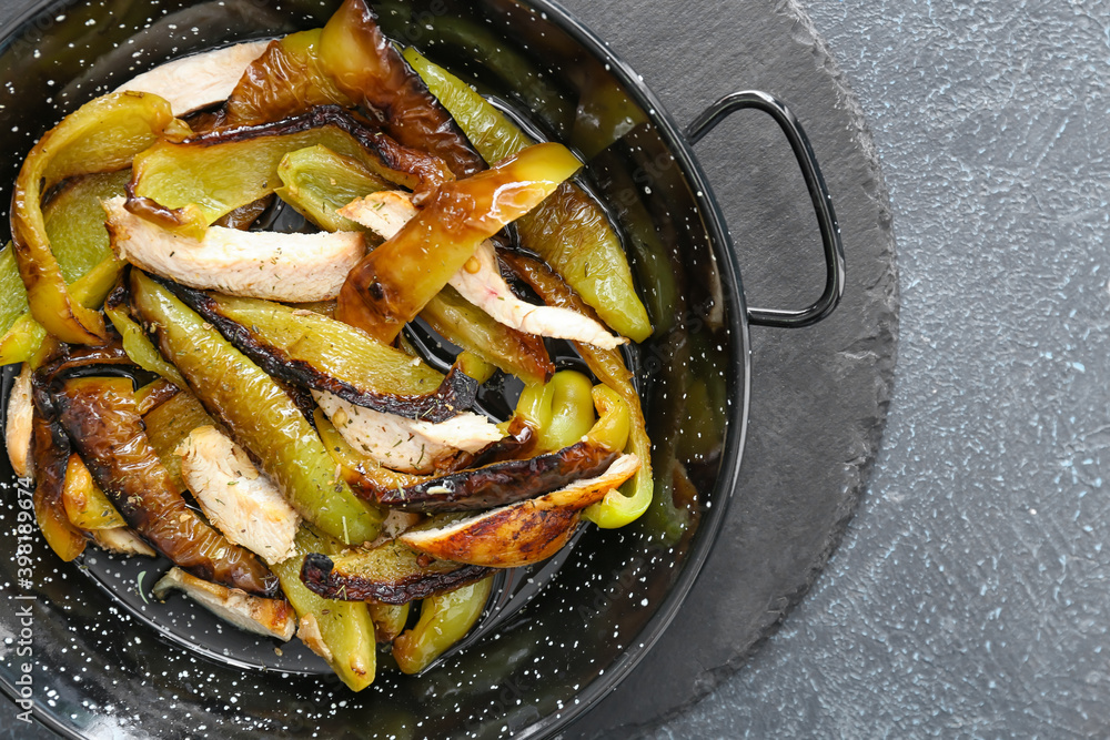 Roasted bell pepper in pan on dark background