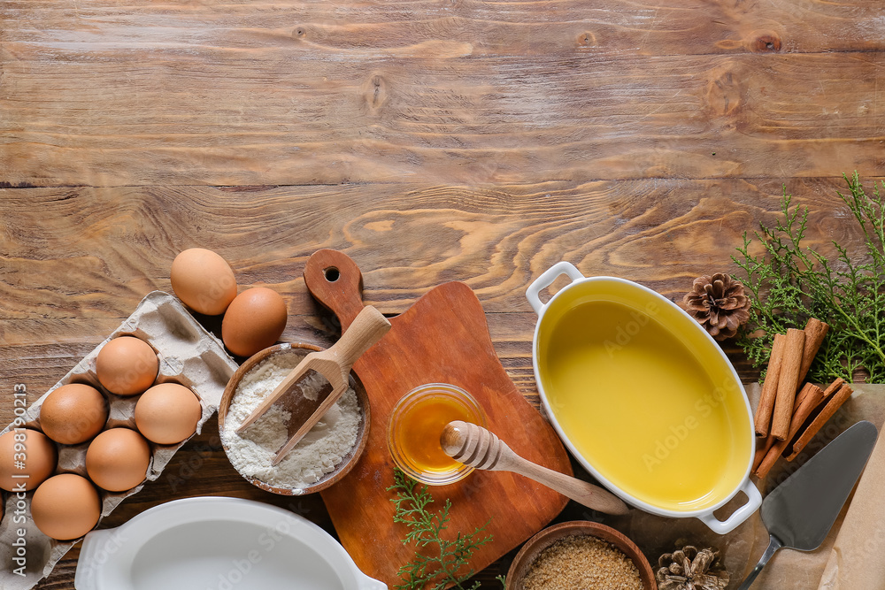 Ingredients for Christmas bakery and kitchen utensils on wooden background