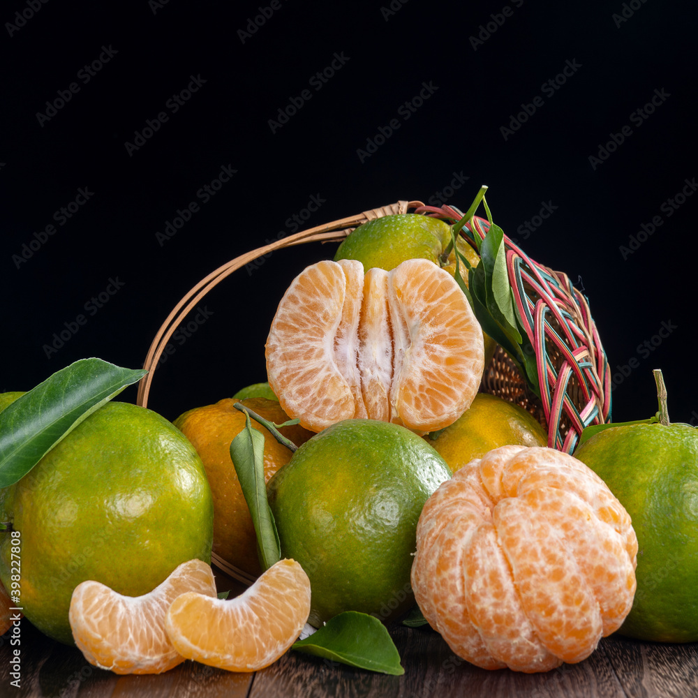 Fresh green tangerine mandarin orange on dark wooden table background.