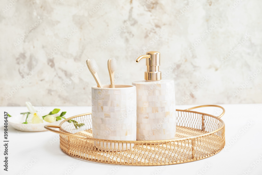 Tray with dispenser and toothbrushes on white table