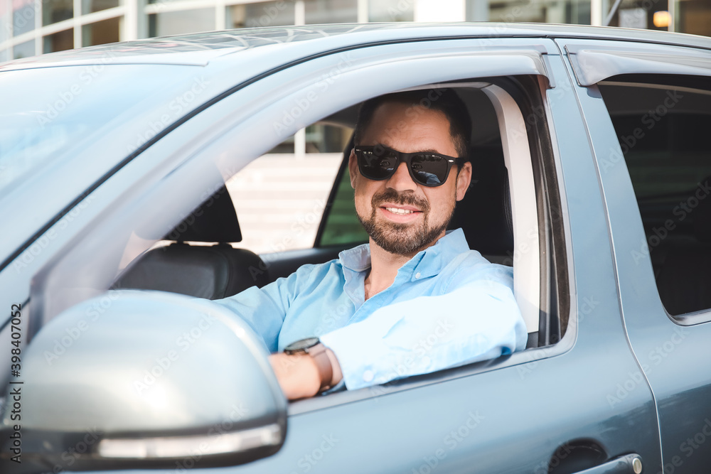 Handsome man driving modern car