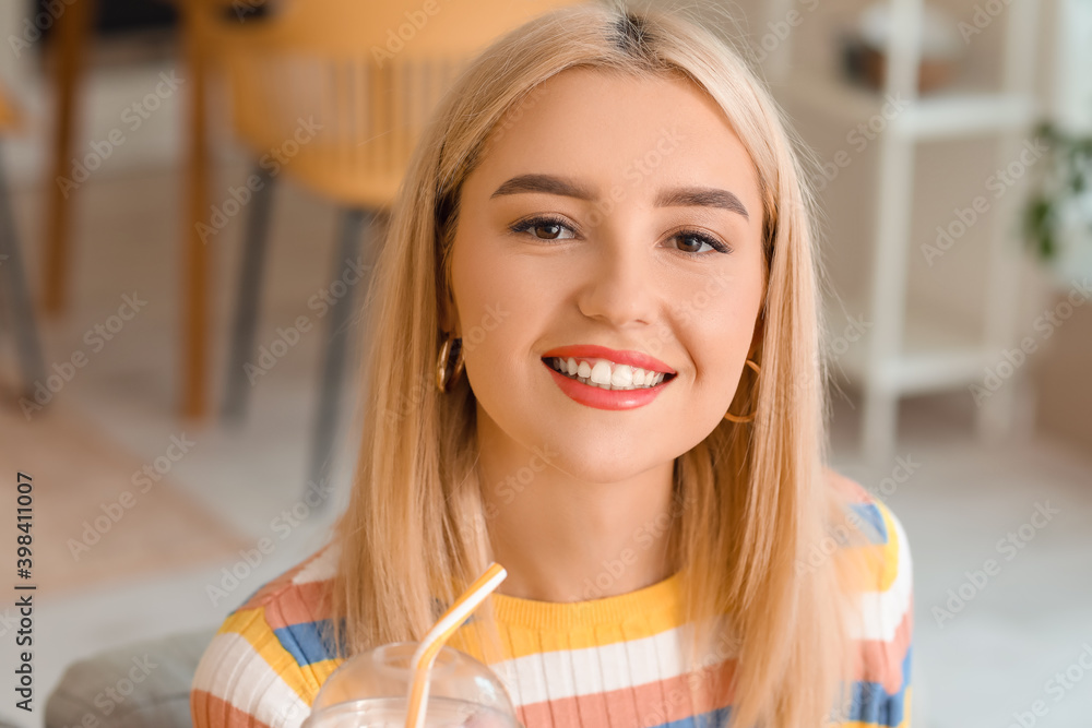 Beautiful young woman drinking fresh juice at home