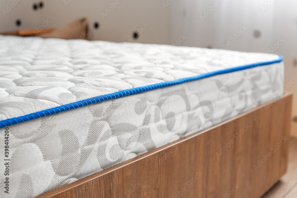 Modern orthopedic mattress on bed in room