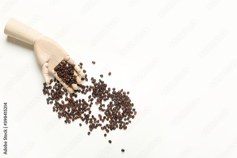 Wooden hand with coffee beans on white background