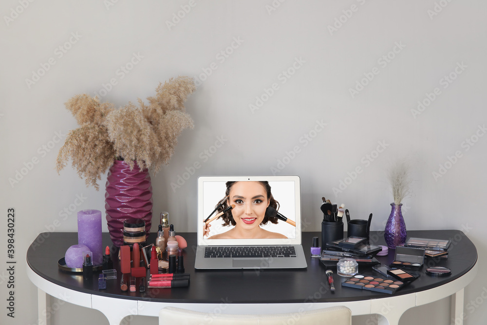 Workplace of professional makeup artist with modern laptop