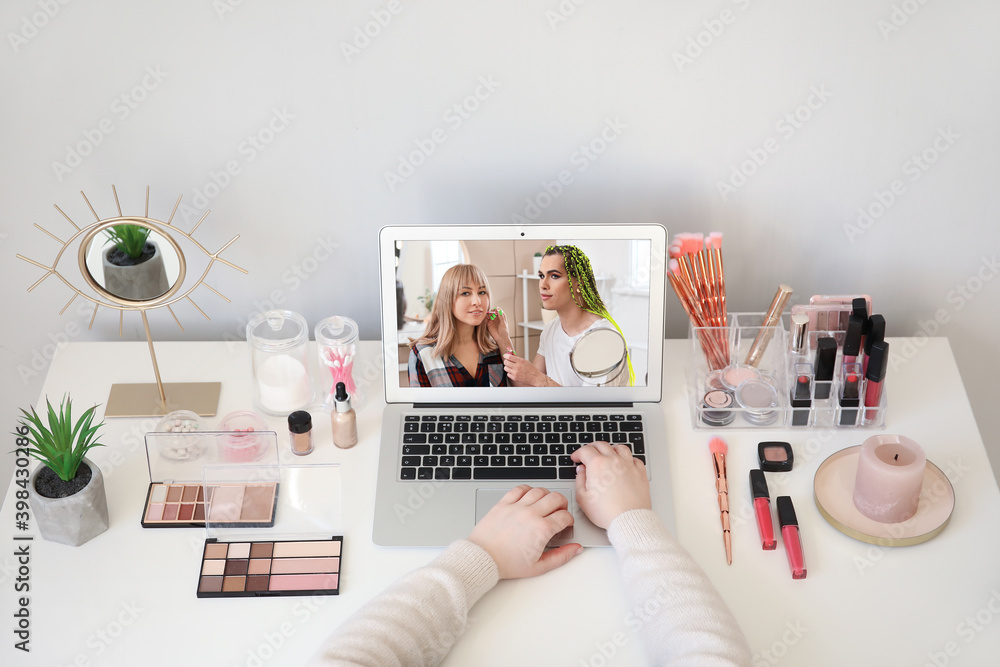 Subscriber at table watching channel of transgender beauty blogger