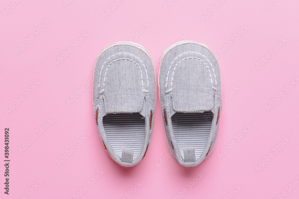 Baby shoes on color background