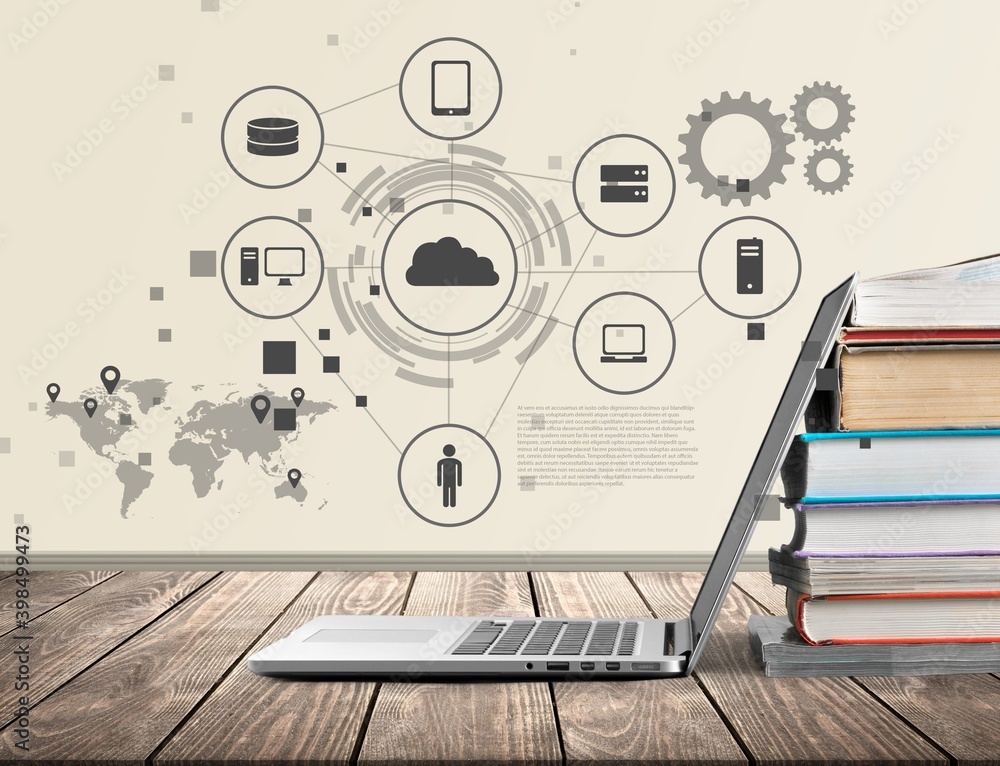 Stack of books with a modern laptop on the table