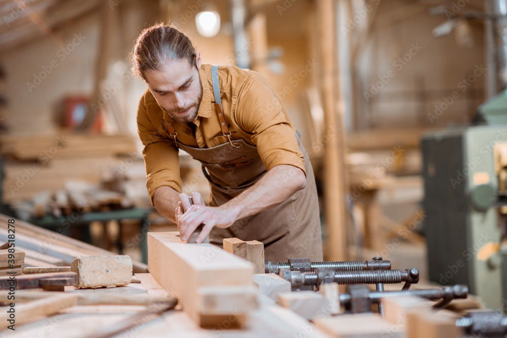 Carpenter working with a wood in the workshop