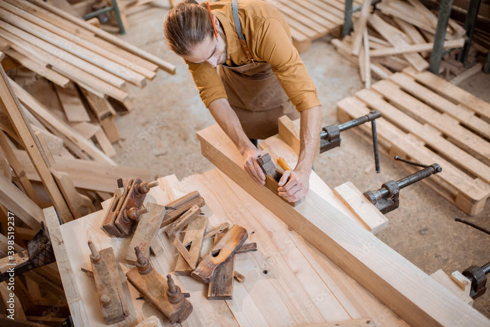 Carpenter working with a wood in the workshop