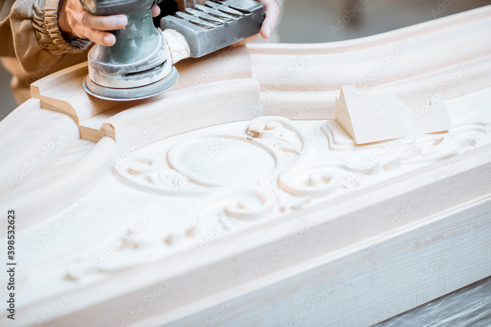 Carpenter grinding joinery product with hand machine, finishing woodwork at the carpentry manufactur