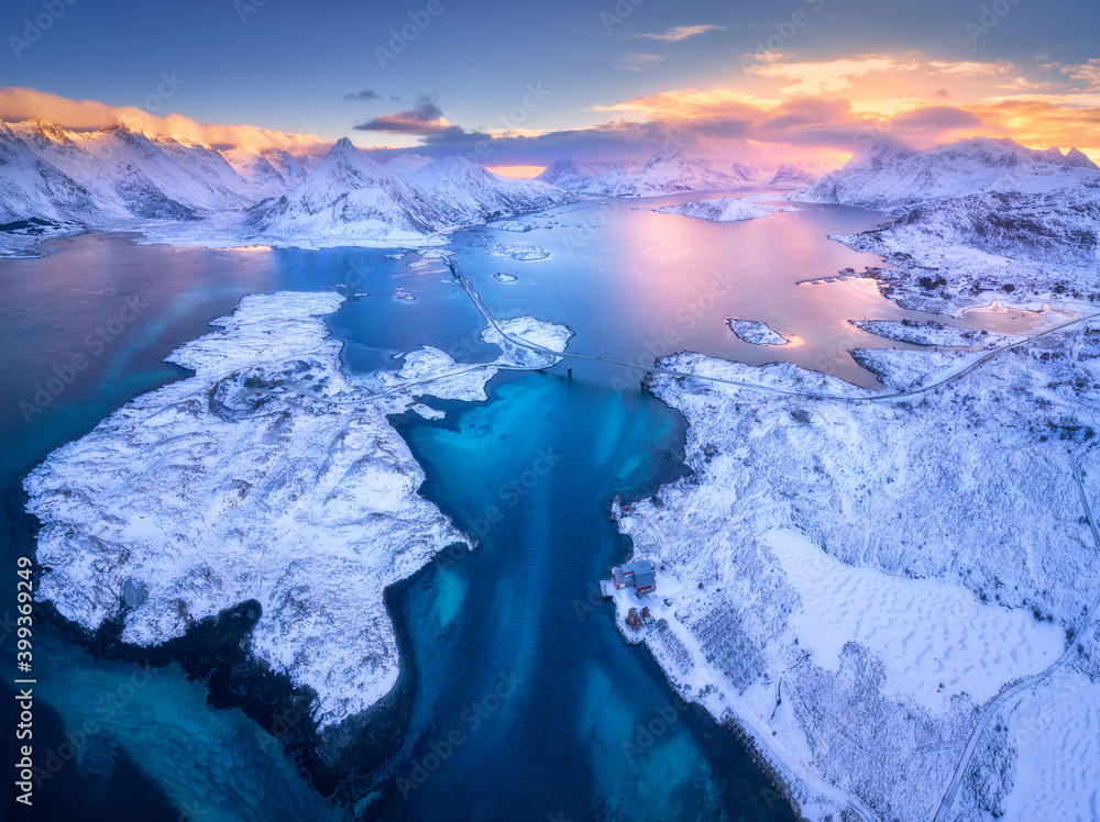 挪威冬季日落时罗弗敦群岛的鸟瞰图。蓝海、雪山的景观