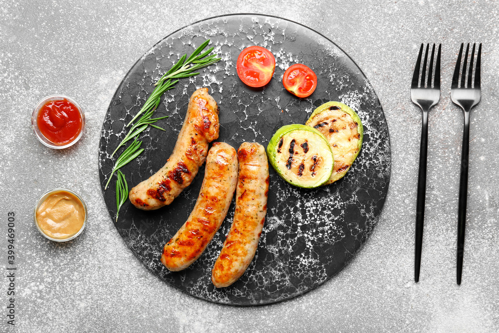 Plate with delicious grilled sausages, vegetables and sauces on table