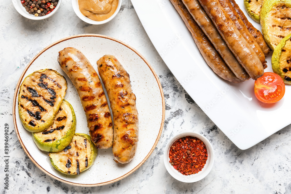 Plate with delicious grilled sausages, vegetables and spices