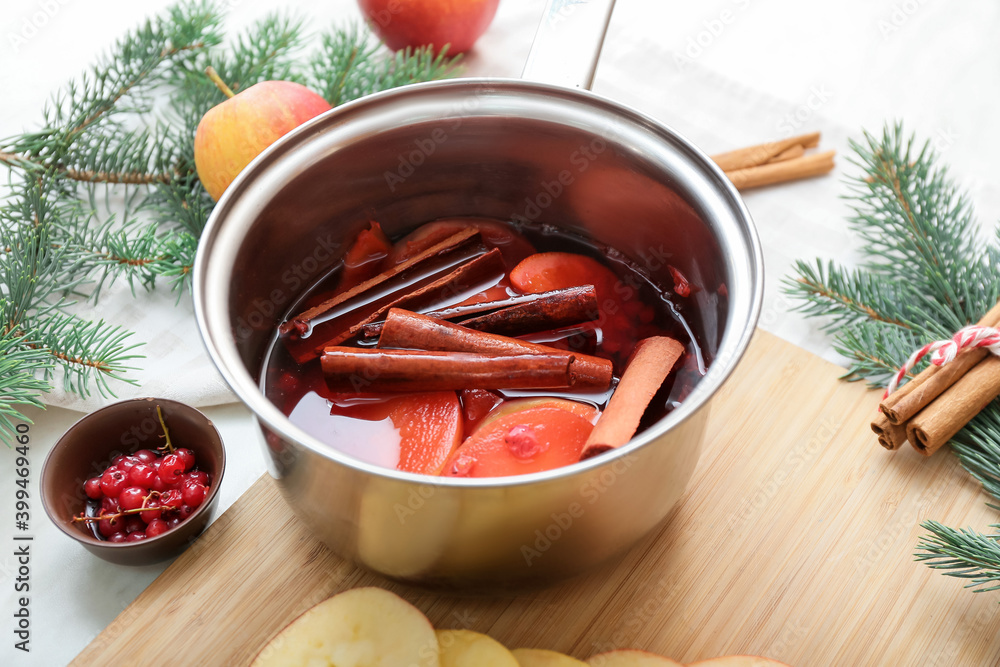 Saucepan with hot mulled wine on table