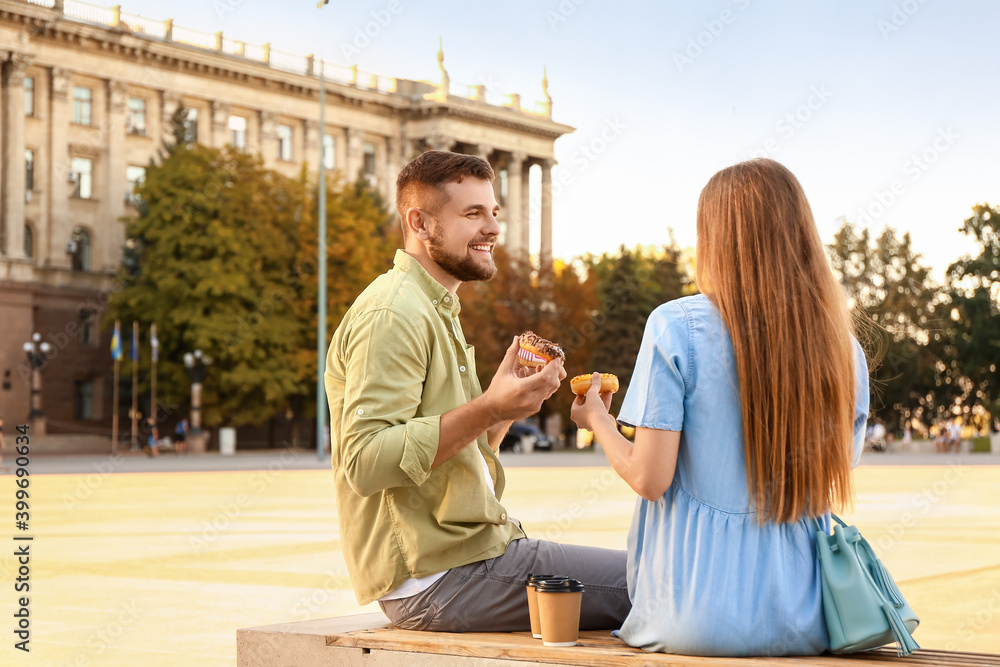 年轻夫妇在户外吃甜甜圈