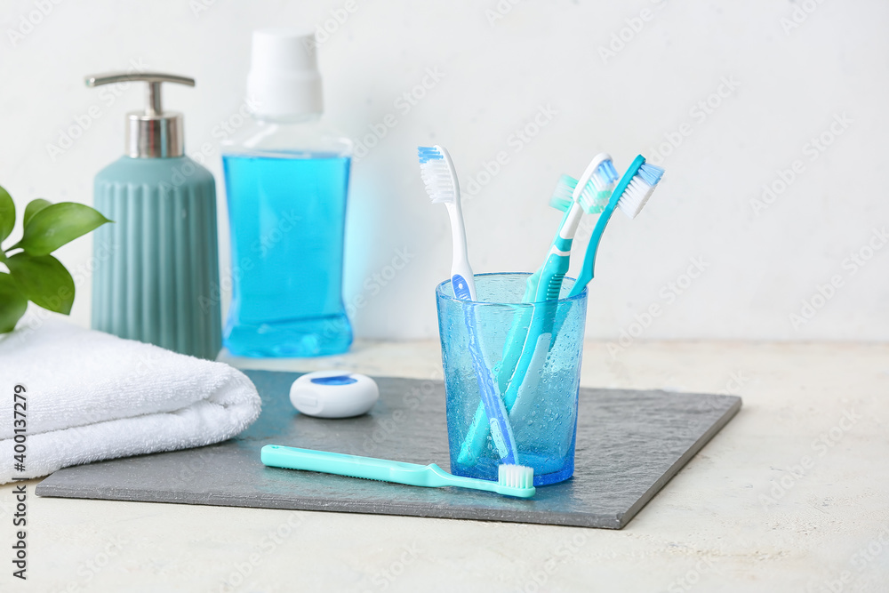 Holder with toothbrushes on table in bathroom