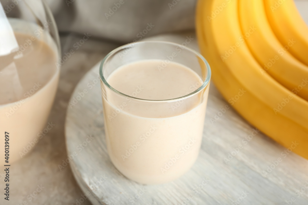 Glass of tasty banana smoothie on table