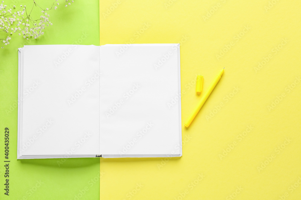 Blank book and pen on color background