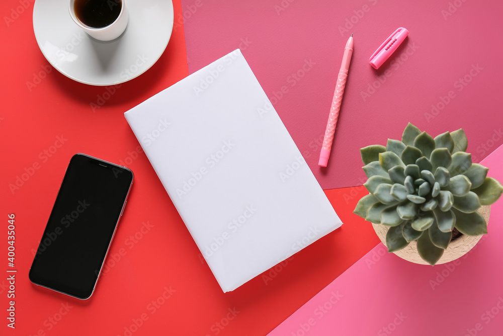 Composition with blank book and phone on color background