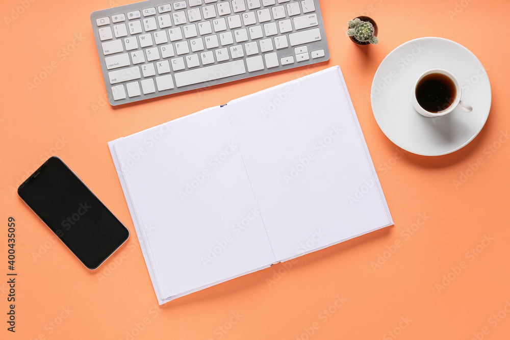 Composition with blank book, phone and computer keyboard on color background