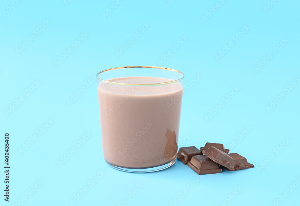 Glass of tasty chocolate milk on color background