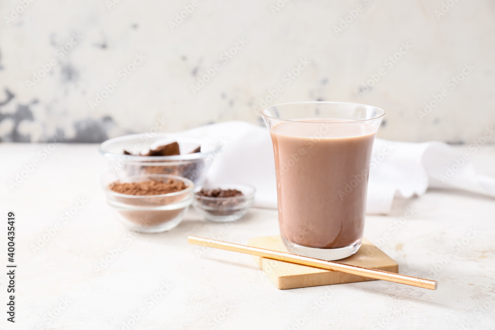 Glass of tasty chocolate milk on table