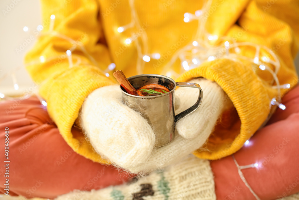 Woman with tasty mulled wine at home, closeup