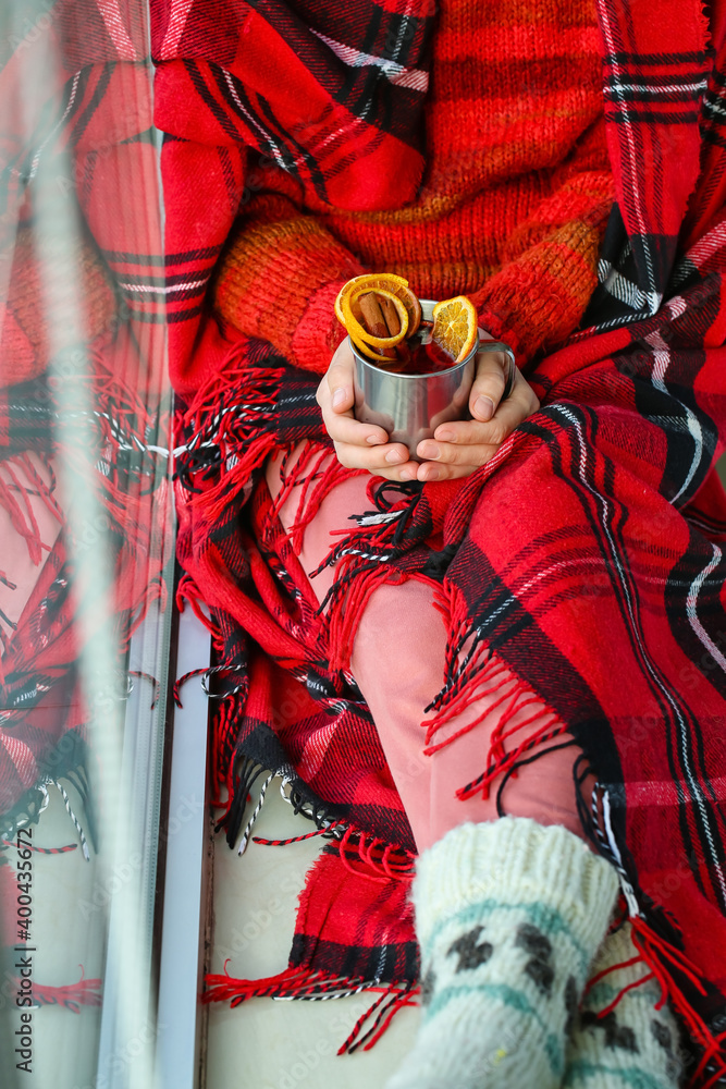 Woman with tasty mulled wine at home