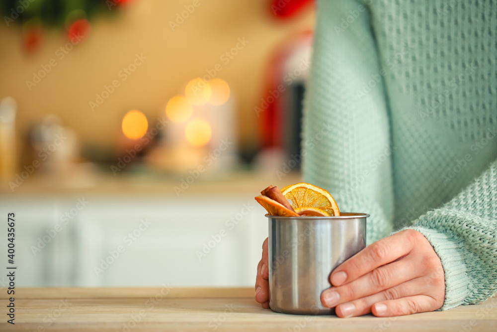 Woman with tasty mulled wine in kitchen