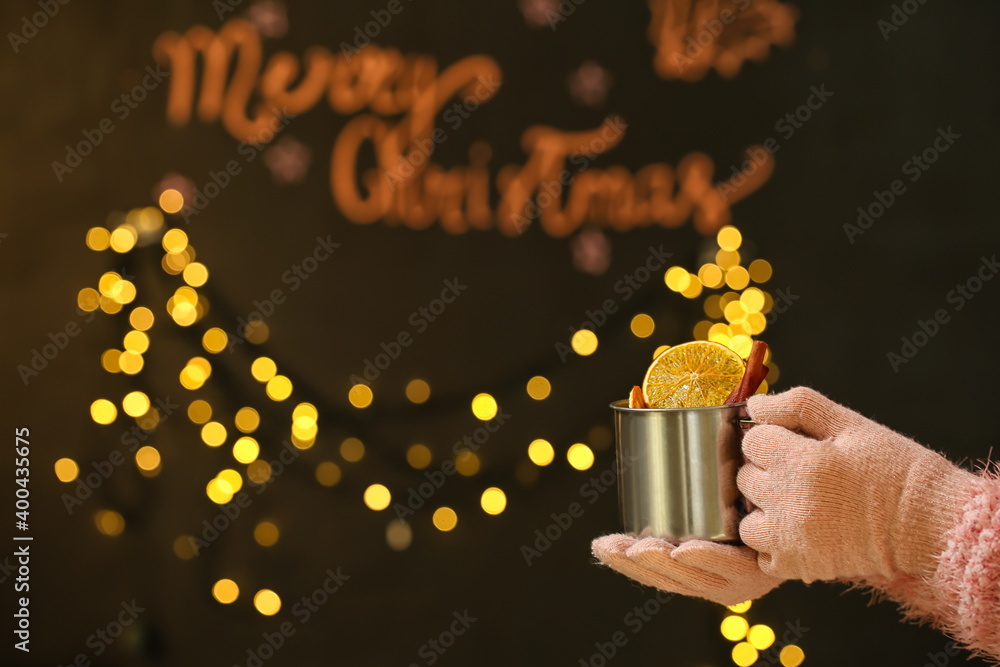 Woman with tasty mulled wine on dark background